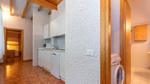 A kitchen with white cabinets, a dishwasher, and a tiled backsplash. - Principe Marmolada 817/A (Rocca Pietore)