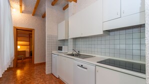 A kitchen with white cabinets, a microwave, a sink, and a dishwasher. - Principe Marmolada 817/A (Rocca Pietore)