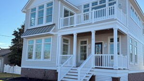 A two-story house with a front porch and a staircase leading to the entrance. - “The Delford” Beach House only Steps to the Bay Beaches (Lower Township)