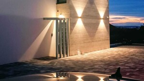 A modern building with a geometric facade and a reflective pool in front.