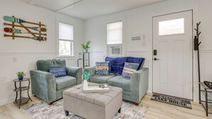 A living room with two grey sofas, a coffee table, and a door with a 'Welcome to Lake House' mat. - Lakefront Gem w/ Watercrafts & Dock in Coldwater! (Coldwater)