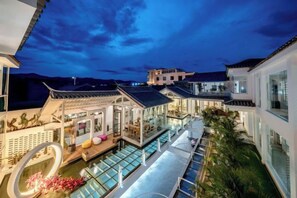 Ein modernes Hotel mit Dachpool, mehreren Etagen und Blick auf die umliegende Landschaft.