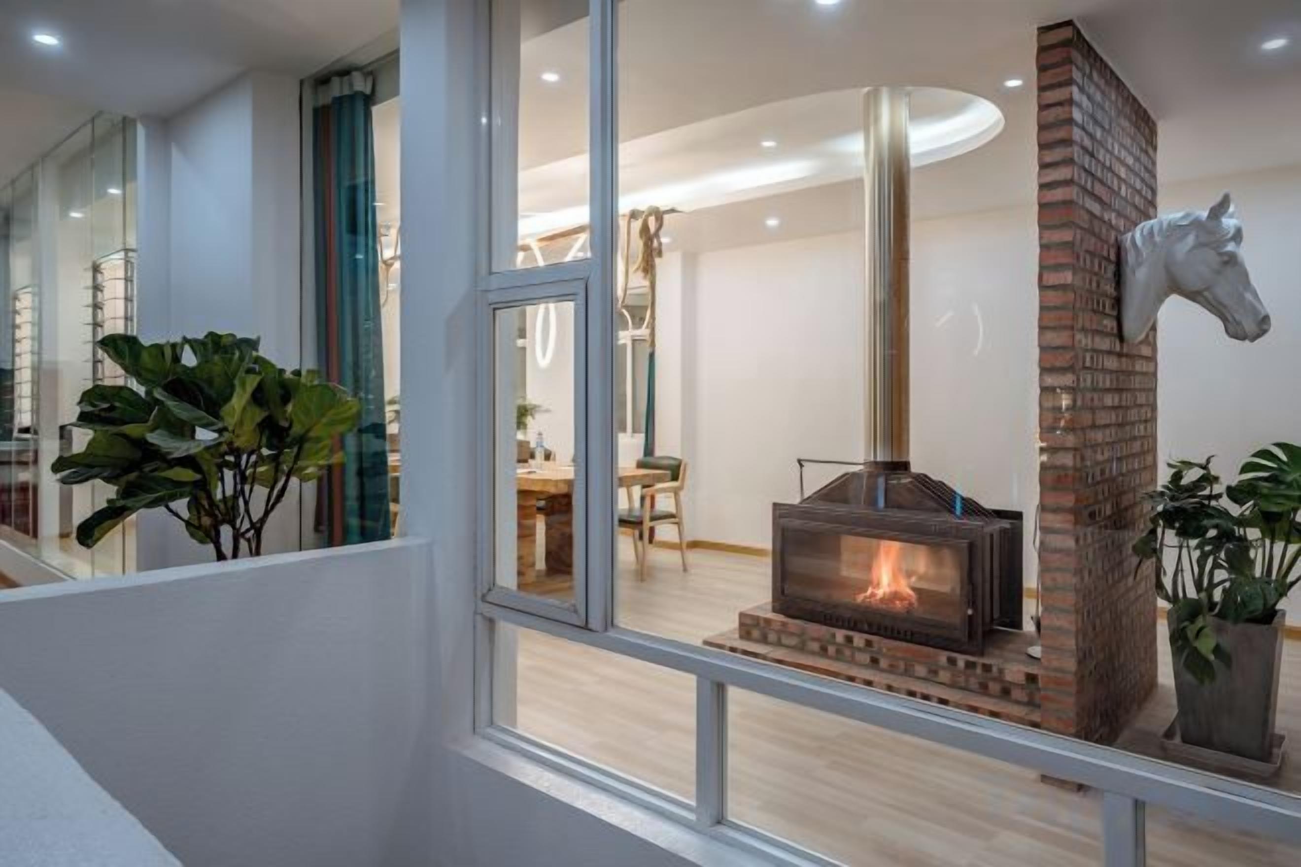 Una habitación con chimenea, comedor y escalera.