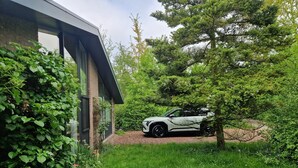 Une maison moderne avec une voiture garée dans l’allée.