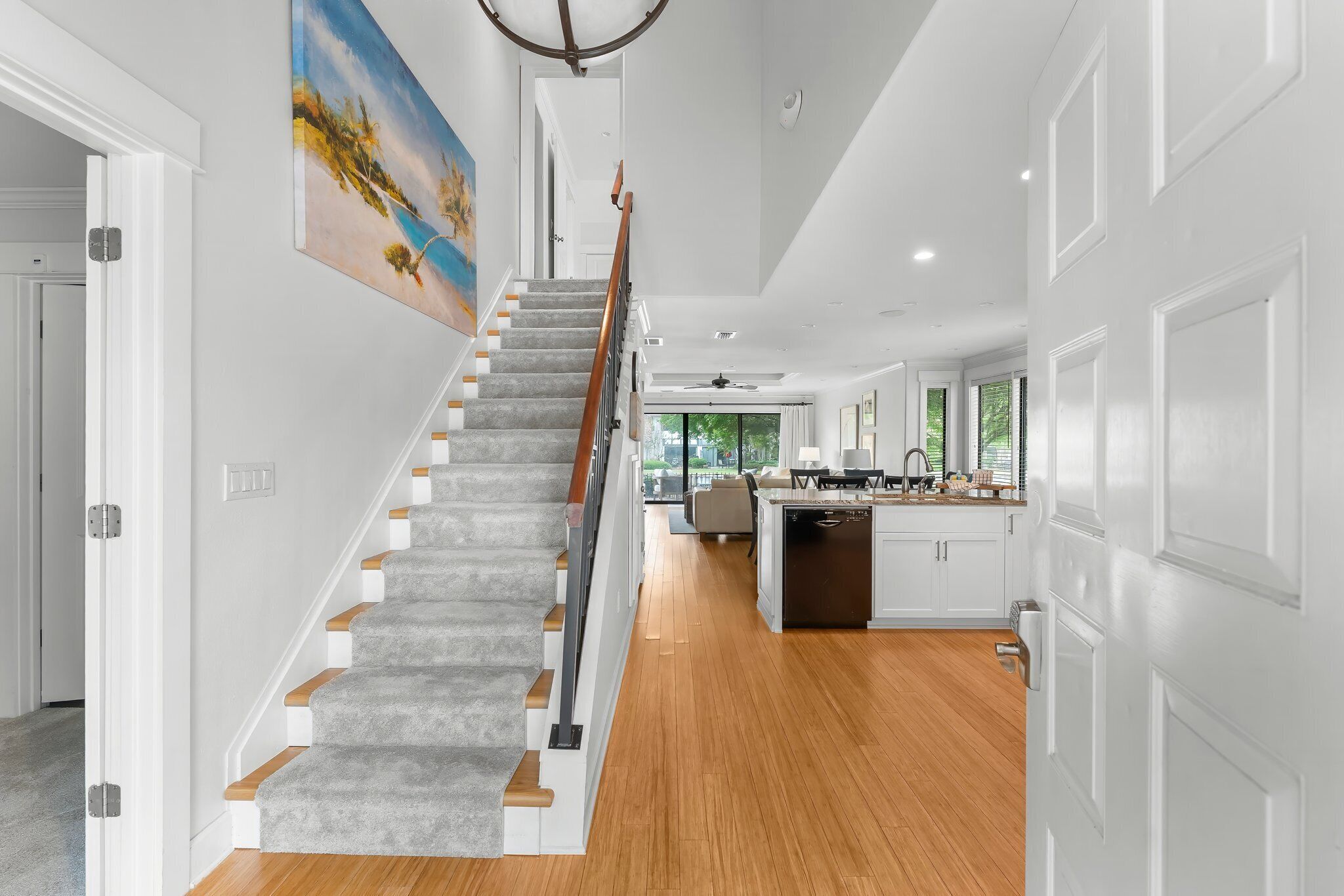 A modern kitchen with white cabinets, a wooden countertop, and a built-in dishwasher.