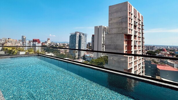 Une piscine sur le toit offrant une vue dégagée sur les immeubles environnants.