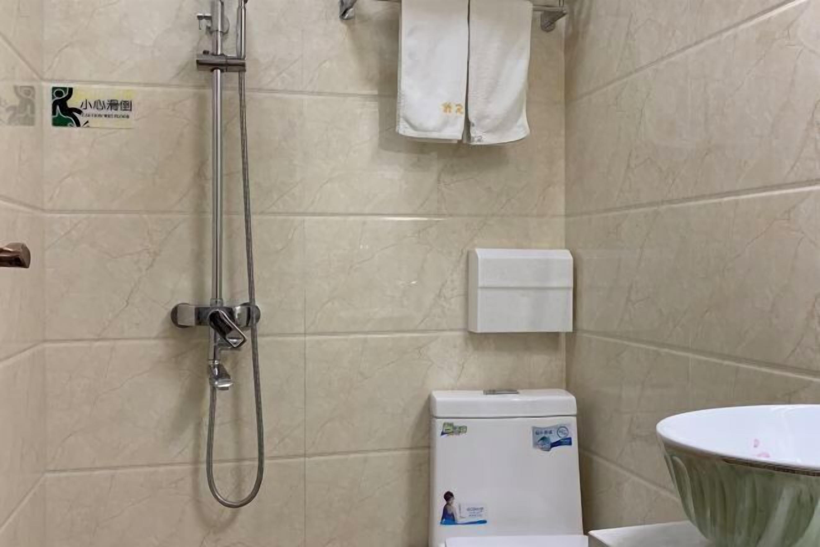 A bathroom with a shower, toilet, and sink.