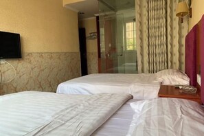 A hotel room with two beds, a television, a glass shower enclosure, and a window with curtains. - Hengtong Hotel (Anqing)