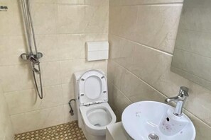 A bathroom with a toilet, sink, and shower. - Hengtong Hotel (Anqing)