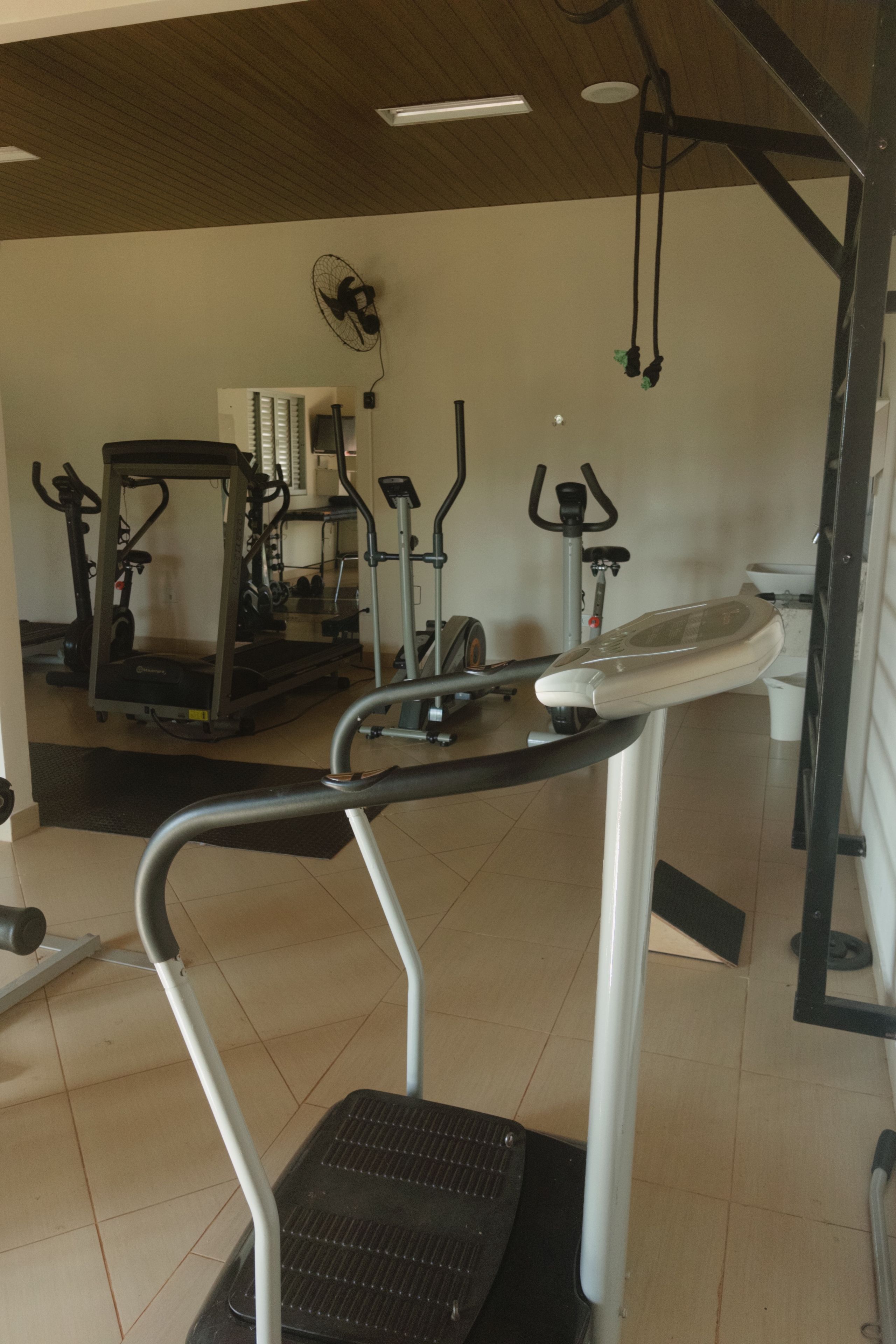 Academia com diversos equipamentos de exercício, incluindo esteiras, bicicletas ergométricas e aparelhos de musculação.