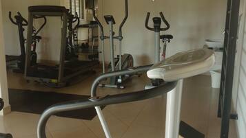 Academia com diversos equipamentos de exercício, incluindo esteiras, bicicletas ergométricas e aparelhos de musculação.