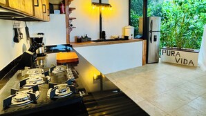 Une cuisine moderne dotée d’un îlot central, de meubles en bois et offrant une vue sur un paysage verdoyant.