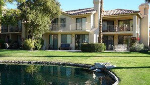 Un bâtiment à deux étages doté d’une piscine, d’une pelouse bien entretenue et d’un espace extérieur aménagé pour s’asseoir.