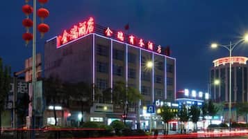 A multi-story building with illuminated signage, likely a hotel or commercial property, featuring a prominent entrance and multiple floors.