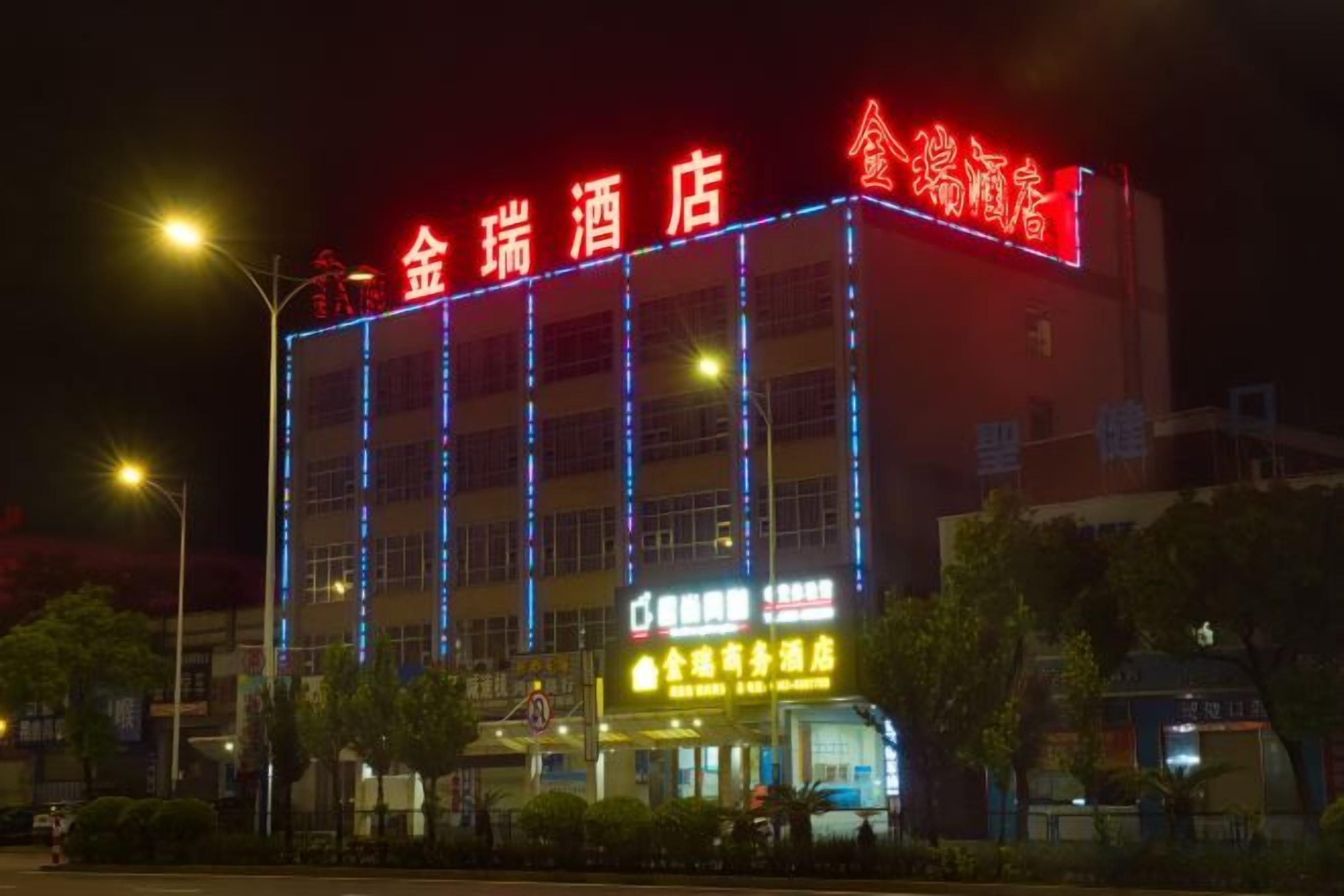 A hotel with illuminated signage, multiple floors, and a visible entrance.