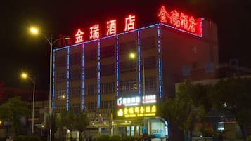A hotel with illuminated signage, multiple floors, and a visible entrance.