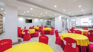 A hotel dining area with round tables and red chairs, some with yellow tablecloths. - Yangjiang Jinrui Business Hotel (Yangjiang)
