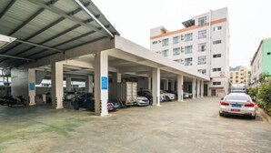 A parking garage with multiple levels and covered walkways, leading to a building with multiple floors and windows. - Yangjiang Jinrui Business Hotel (Yangjiang)