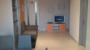 A living room with a sofa, a television, and a cabinet. - Apartments Radacic (Marina)