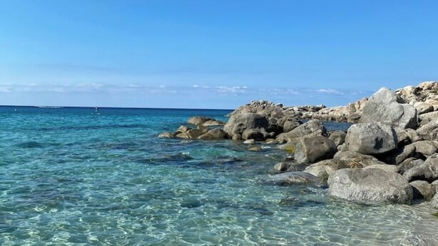 Una costa rocosa con aguas azul cristalino.