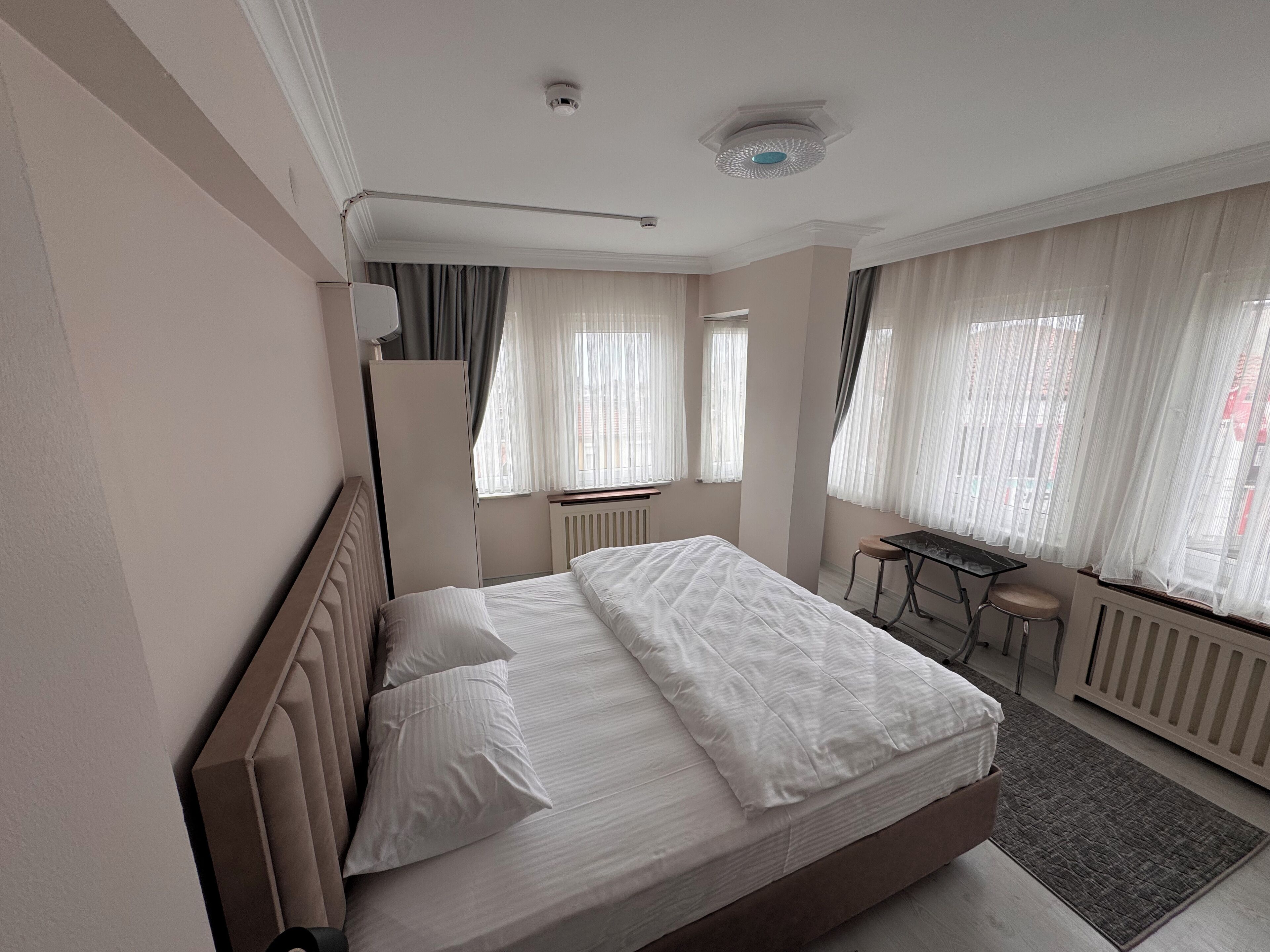 Una habitación de hotel con una cama grande, una mesita y una silla.