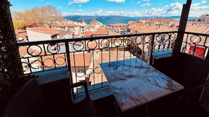 Un balcón con vista a la ciudad y al mar.