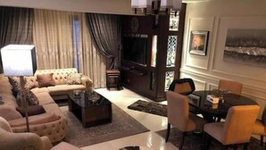 A living room with a sofa, coffee table, and a round rug. - 3 bedrooms Duplex 90 st. parkmall residence (New Cairo City)