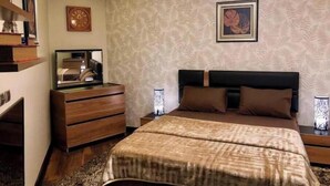 A bedroom with a bed, wooden dresser, nightstands, a mirror, and a chandelier. - 3 bedrooms Duplex 90 st. parkmall residence (New Cairo City)
