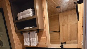 Een kleine badkamer met toilet, wastafel en een douchecabine van glas.
