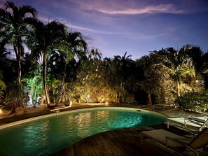 A swimming pool surrounded by tropical vegetation and wooden deck chairs. - Villa Kalaou- Golf St François- Private pool and garden - 3 bdr,, 3 bathrooms (Saint-François)