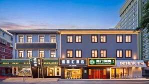 Un hôtel à l’architecture moderne, doté d’une façade élégante, de nombreuses fenêtres et d’enseignes indiquant différents commerces, notamment un restaurant et un spa.