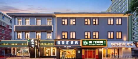 A hotel with a modern facade, multiple windows, and signage for various businesses including a restaurant and a spa.