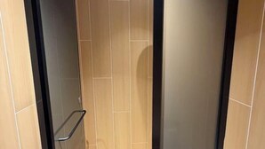 Une salle de bain avec un plancher en bois, un porte-serviettes et des toilettes.