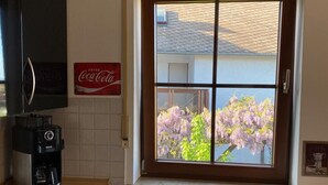 Une cuisine avec une fenêtre, une machine à café et une enseigne Coca-Cola.