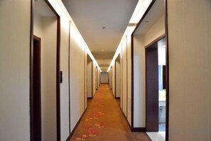 A long, narrow hotel corridor with doors on both sides, leading to individual rooms. - Taixi Hotel (Feicheng)