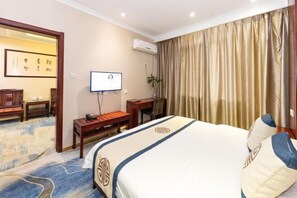 A hotel room with a bed, a desk, a chair, a television, and a curtain. - Taixi Hotel (Feicheng)