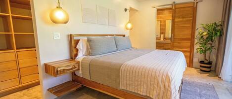 Ein Schlafzimmer mit einem hölzernen Bett, einem Deckenventilator, einer Wandleuchte, einem Kleiderschrank und einer Topfpflanze.