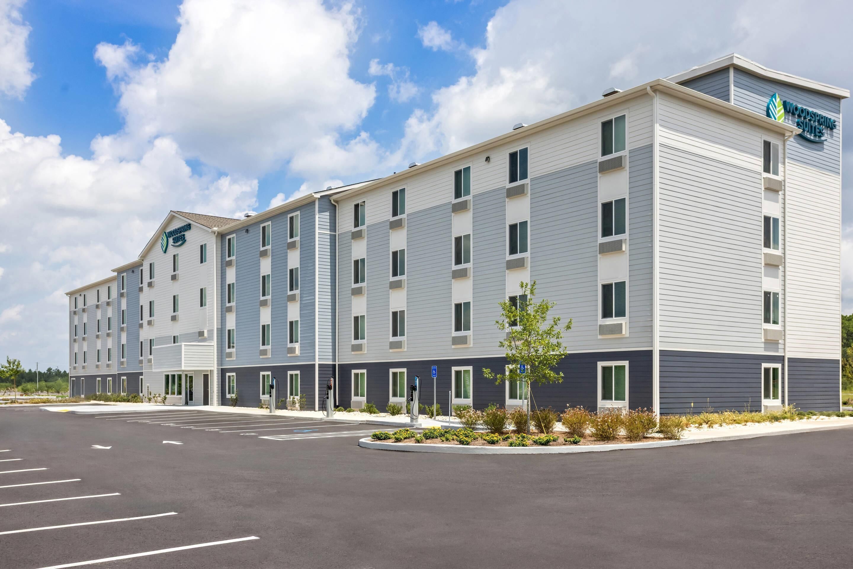 Ein mehrstöckiges Hotel mit modernem Design und einem Parkplatz davor.