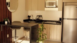 A modern kitchen with a central island, stainless steel appliances, and a wooden cabinet. - Loft Pool Loft in Chapultepec (Guadalajara)