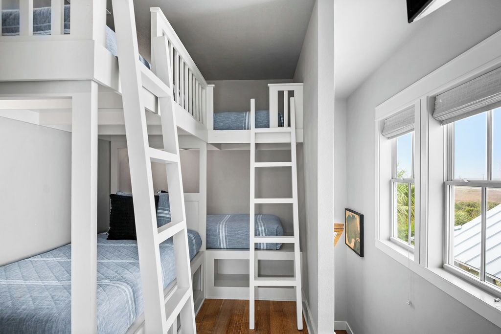 A compact room with bunk beds, a ladder, and a window with a view.