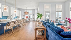A spacious living area with a blue sofa, wooden coffee table, and wicker chairs. - Sweet Retreat 405 RET (Port Aransas)
