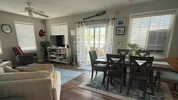 A living room with a sofa, a TV, a dining table with chairs, and a ceiling fan. - Spacious 5-bedroom house in beautiful Belmar w/ WiFi.  2 blocks from the beach! (Belmar)