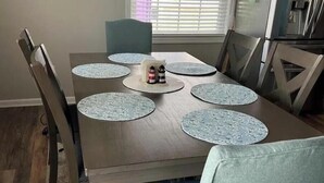 A dining table with six chairs, each with a placemat. A bottle of hot sauce is on the table. - Spacious 5-bedroom house in beautiful Belmar w/ WiFi.  2 blocks from the beach! (Belmar)