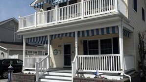 A two-story house with a front porch, a garage, and a driveway. - Spacious 5-bedroom house in beautiful Belmar w/ WiFi.  2 blocks from the beach! (Belmar)