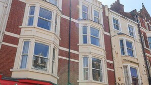 A multi-story building with bay windows and a red brick facade. - The Newborough Apartment 1 (Scarborough)