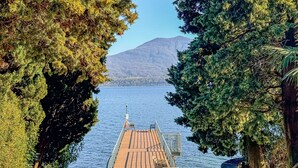 A wooden dock extending into a lake, surrounded by dense trees. - Vera apartment with wonderful terrace lake view (Oggebbio)