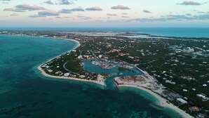 An aerial view of a coastal resort with a marina, beachfront properties, and a large body of water.
