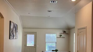 A dining area with a table, chairs, and a window with blinds.