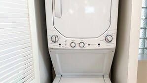 Un appareil compact combinant lave-linge et sèche-linge, doté d’un panneau de commande avec de nombreux réglages et boutons.