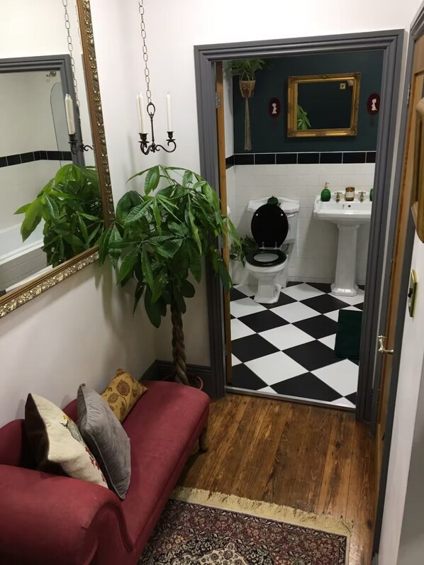A bathroom with a black and white checkered floor, a white sink, and a toilet.